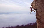 John Arran swinging above the morning mist on LHorla a climb on Curbar Edge in the Peak District small